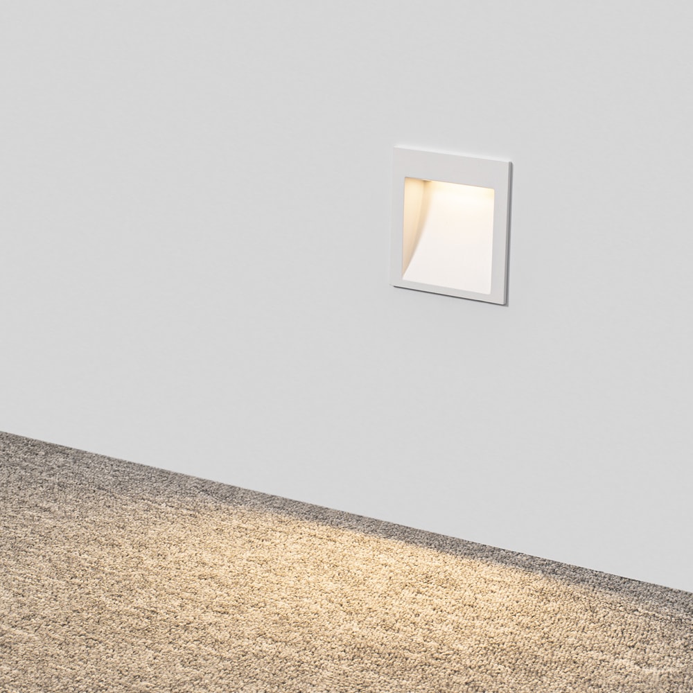 R902 low glare stair light in a hallway wall with the light spilling onto a carpet floor
