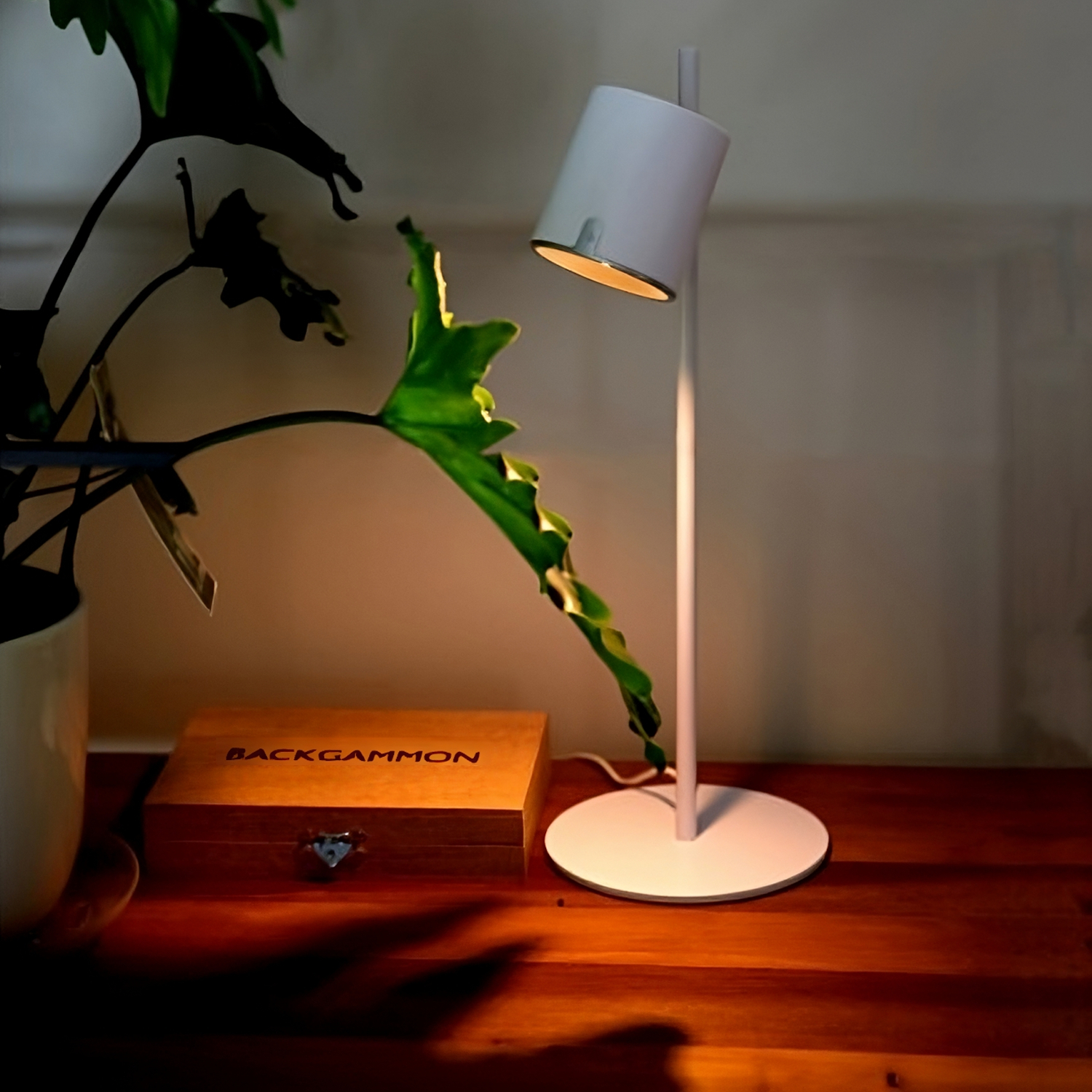 Product image of Arlo White Table lamp on a wooden desk, the light is on illuminating the desk