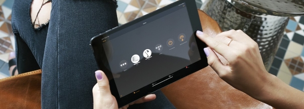 a person is controlling their lighting with the casambi app on a tablet